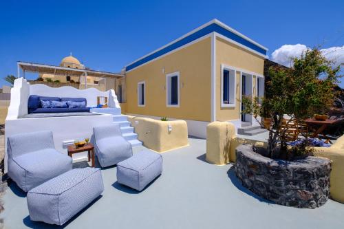 a patio with chairs and a bed and a house at Pasithea Suites in Megalokhori