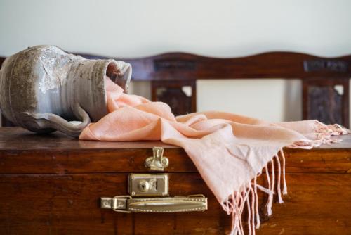 a vase sitting on top of a dresser with a pink towel at Pasithea Suites in Megalokhori