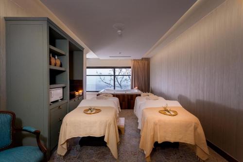 a room with four beds and a window at Mizpe Hayamim by Isrotel Exclusive in Rosh Pinna