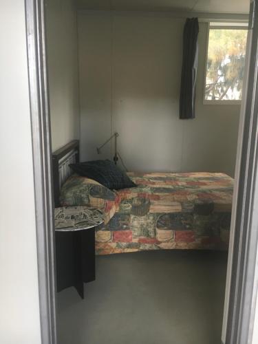 een slaapkamer met een bed en een raam bij Something Different - Shedstay in Donnybrook