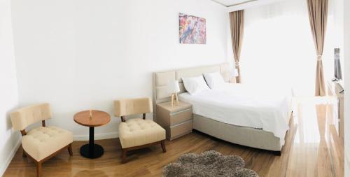 a bedroom with a bed and a table and chairs at White Tower Mamaia Apartament in Mamaia