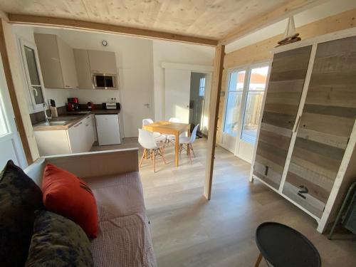 un salon avec un canapé et une cuisine avec une table dans l'établissement Appartements Les Homards du Fier #3, à La Guérinière