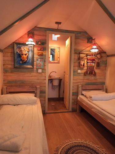 a bedroom with two beds in a room with wooden walls at Samskara-Beach in Călăraşi