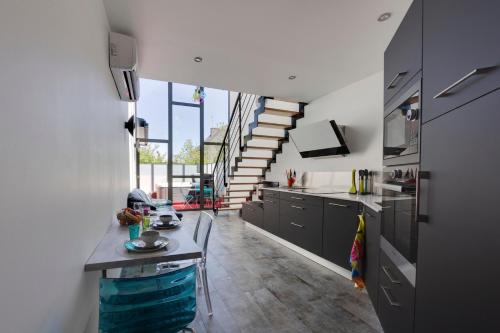 une cuisine avec des armoires noires et un escalier en colimaçon dans l'établissement L'Albatros, à Landerneau