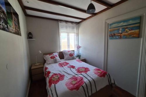 a bedroom with a bed with pink flowers on it at la lauch in Colmar
