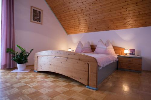 1 dormitorio con 1 cama grande y techo de madera en Ferienwohnungen Starmuz, en Obersammelsdorf