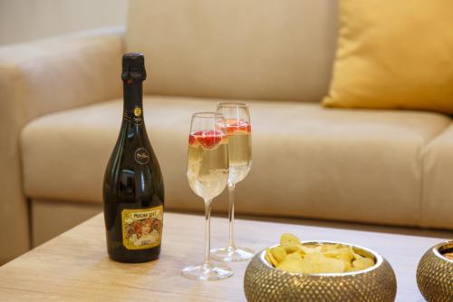a bottle of champagne and two glasses on a table at Apartments Villa Whitehouse in Ostrava