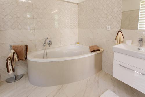 a white bathroom with a tub and a sink at Apartments Villa Whitehouse in Ostrava