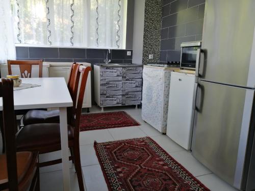 a kitchen with a white refrigerator and a table with chairs at Apartman Đorđević in Soko Banja