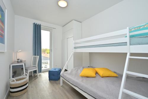 - une chambre avec des lits superposés et 2 oreillers jaunes dans l'établissement ArkonaPanorama, à Glowe