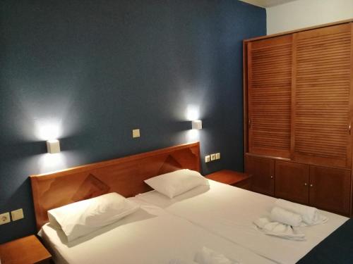 een slaapkamer met een bed met 2 kussens erop bij Eleni Beach Apartment in Stalida