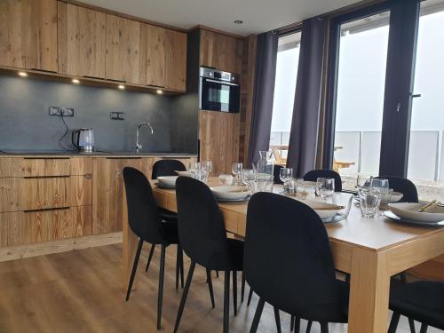 une salle à manger avec une table et des chaises en bois dans l'établissement Les étoiles de la plagne le Diamant, à Mâcot La Plagne
