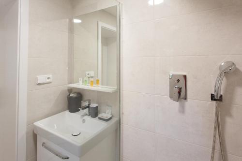 a white bathroom with a sink and a shower at Apartments Villa Whitehouse in Ostrava
