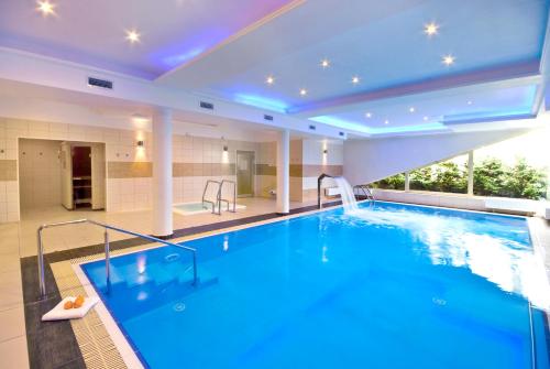 a large swimming pool in a hotel room with a large swimming pool at Villa Arstone in Świnoujście