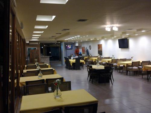 uma sala de jantar com mesas e cadeiras e mesa de cabeceira em Hotel Niko Paradise em Platamonas