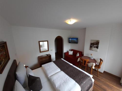 a bedroom with a bed and a table and chairs at Gästehaus Burgi in Fügen