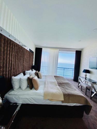 a bedroom with a large bed with a large window at Maristella Marine Residence in Odesa