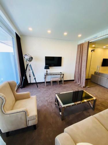 a living room with two couches and a television at Maristella Marine Residence in Odesa