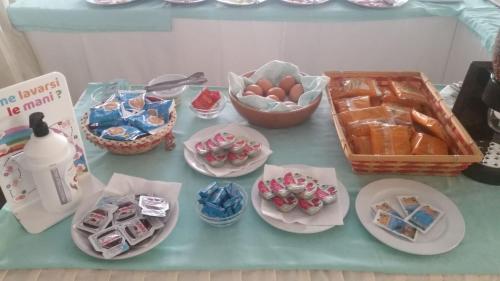 een tafel met borden en kommen met voedsel bij Hotel Dall'Ara in Villa Marina