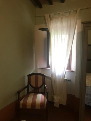 a small room with a chair and a window at La Locanda del Loggiato in Bagno Vignoni