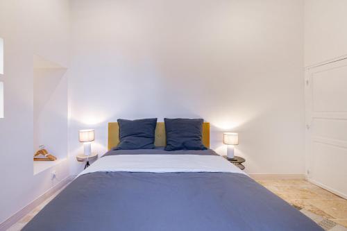 um quarto com uma cama grande e almofadas azuis em B&B du Couvent, chambre aux paons em Giroussens