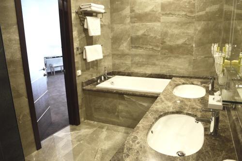 a bathroom with a sink and a bath tub at Maristella Marine Residence in Odesa