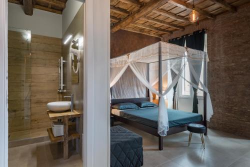 a bedroom with a canopy bed and a sink at Le Boutique Luxury Rooms in Fiumicino
