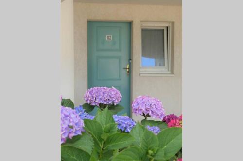 una puerta con flores púrpuras delante de una casa en Studio situé dans le centre de Saint Philibert en Saint-Philibert