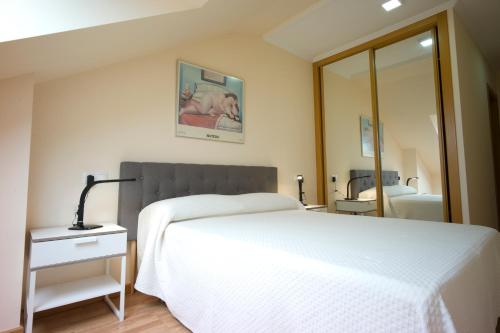 バレイロスにあるAtico Premium Playa Altar 4のベッドルーム(白いベッド1台、鏡付)