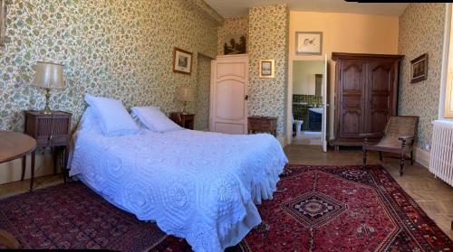 a bedroom with a bed with a blue comforter at La Buffonnerie in Moutiers-Saint-Jean