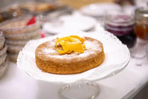 a cake on a white plate on a table at Agritur Acetaia Gourmet&Relax in Tenno