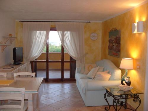sala de estar con sofá blanco y mesa en Marinella, Sardegna en Marinella