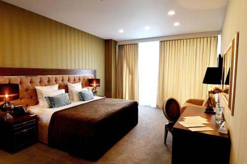a hotel room with a bed and a desk at Maristella Marine Residence in Odesa
