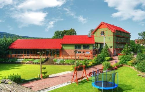 a house with a playground in front of it at Ośrodek Wypoczynkowy MAX in Jarnołtówek
