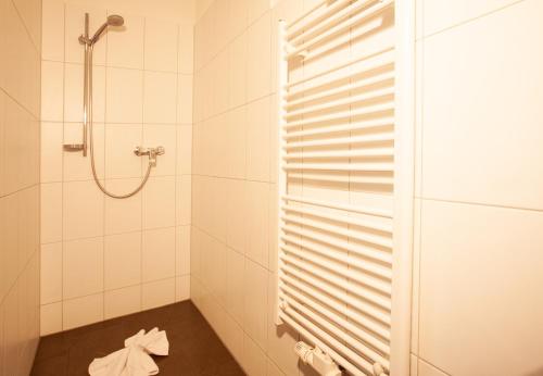 a bathroom with a shower and a towel on the floor at Apartments Drei Türme by Pferd auf Wolke in Schruns-Tschagguns