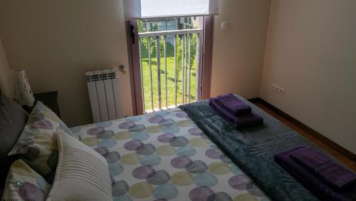 ポボア・デ・バルジンにあるApartamento Oceanus Parkのベッドルーム1室(紫のシーツが敷かれたベッド1台、窓付)