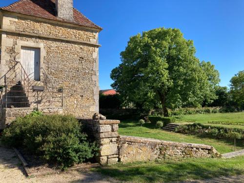 an old stone building with a tree in the background at La Buffonnerie in Moutiers-Saint-Jean