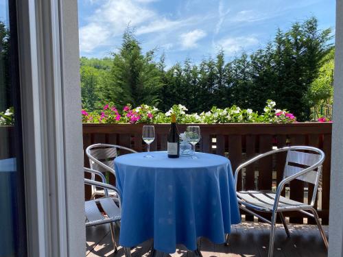 a table with a bottle of wine and two glasses at Garni San Paolo in Appiano sulla Strada del Vino