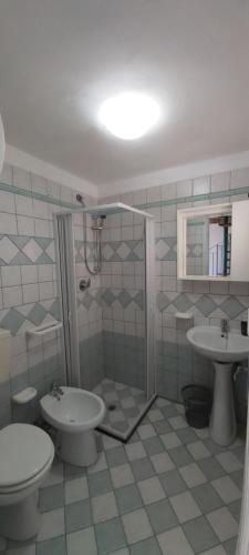 een badkamer met een douche, een toilet en een wastafel bij Villa Anna, con patio vista mare in Castellammare del Golfo