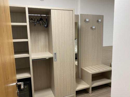 a closet with wooden shelves and a door at Garni San Paolo in Appiano sulla Strada del Vino