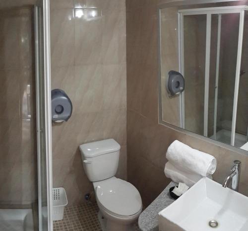 La salle de bains est pourvue de toilettes, d'un lavabo et d'un miroir. dans l'établissement Express Inn Coronado & Camping, à Playa Coronado