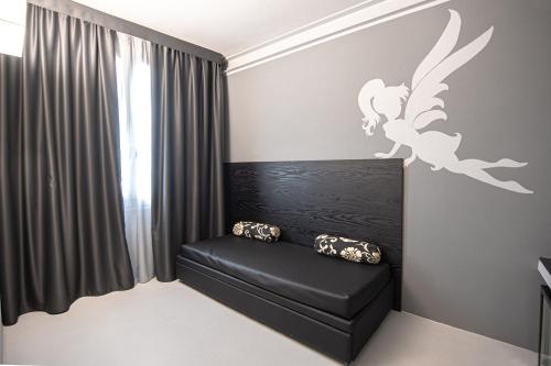 a room with a black leather couch and a bird decal on the wall at Hotel Villa delle Fate, BW Signature Collection in Sestola