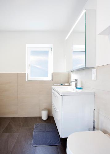 a bathroom with a sink and a toilet and a window at Isiliving in Montabaur