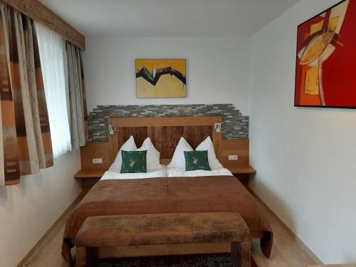 a bedroom with a large bed with green pillows at Pension Ballwein in Salzburg