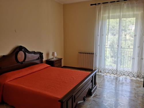 sypialnia z łóżkiem i dużym oknem w obiekcie Casa Catena w mieście Francavilla di Sicilia