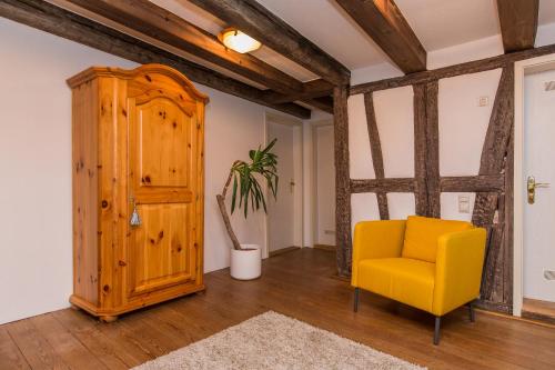 a room with a yellow chair and a cabinet at Ferienwohnung Rottweil Zentrum in Rottweil