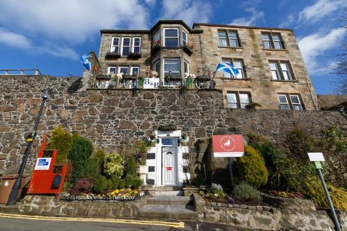un grande edificio in pietra con una porta bianca di Castle Walk Bed & Breakfast a Stirling