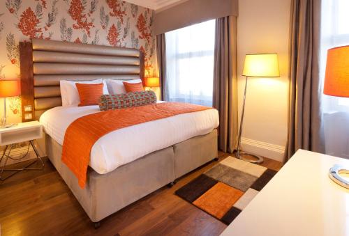 a bedroom with a bed with orange pillows and a window at Hotel Indigo Edinburgh by IHG in Edinburgh