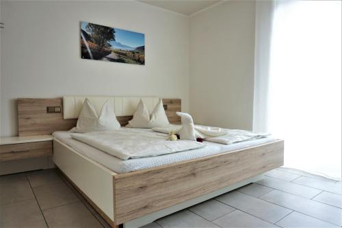 a bedroom with a large bed with a wooden headboard at Zum Schwarzen Kus in Caldaro