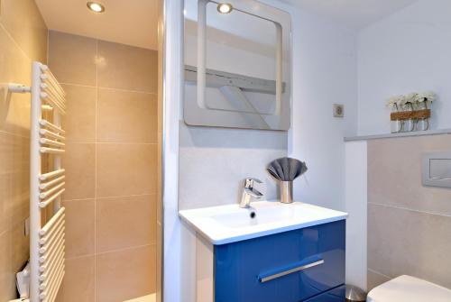 a bathroom with a blue sink and a mirror at Appartement La petite terrasse sur les toits in Colmar